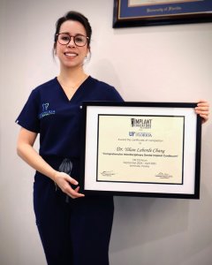 Dr. Yilian Laborde Chang holding a framed certificate